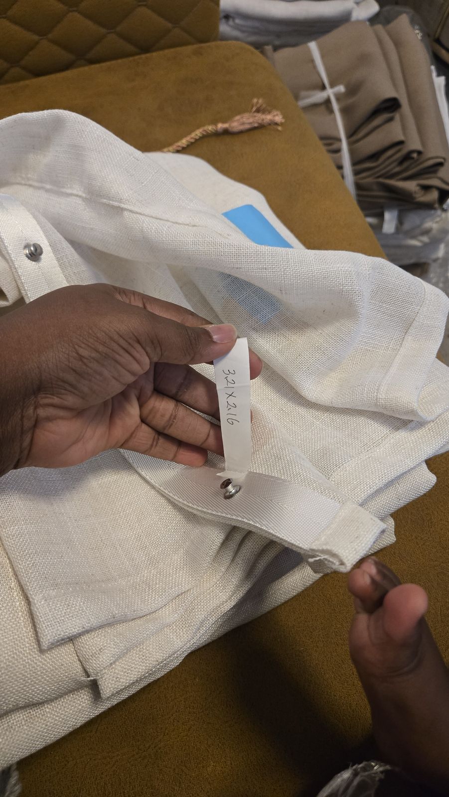 Hands working a hem during curtain fabrication