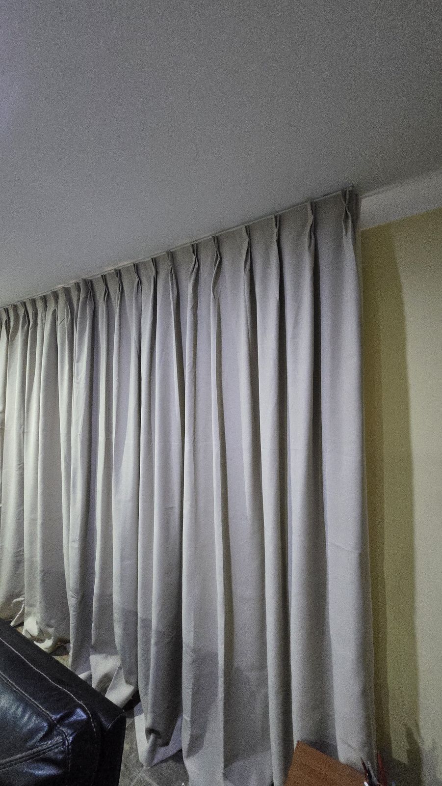 Ivory curtains pooling on stone-look tiles after install