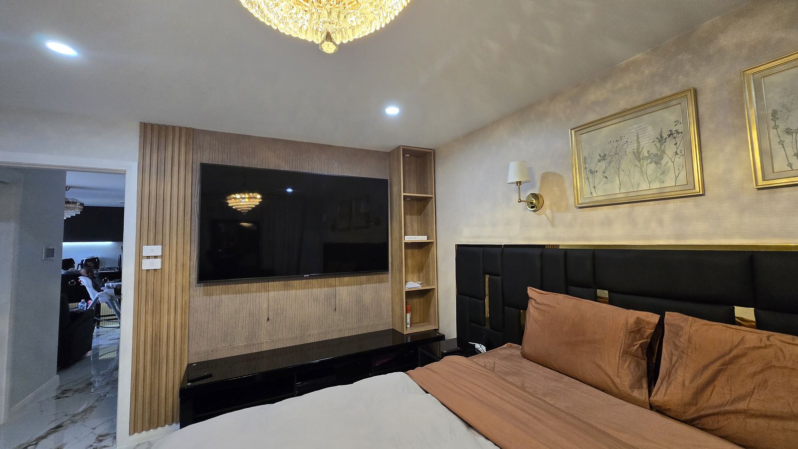The noir suite — timber slat TV wall and black leather bedhead detail