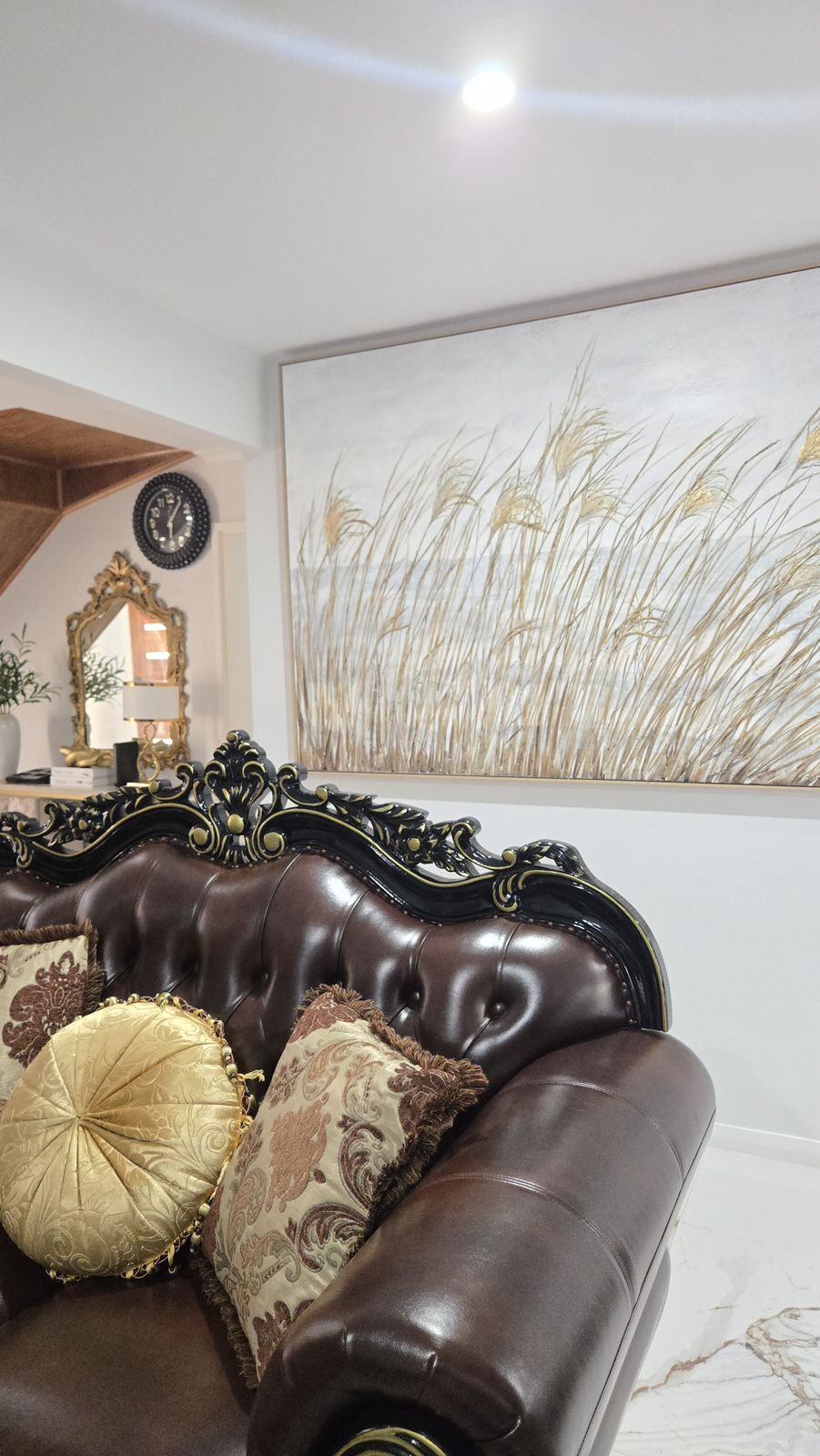 Chesterfield-style leather sofa with gold silk pillows