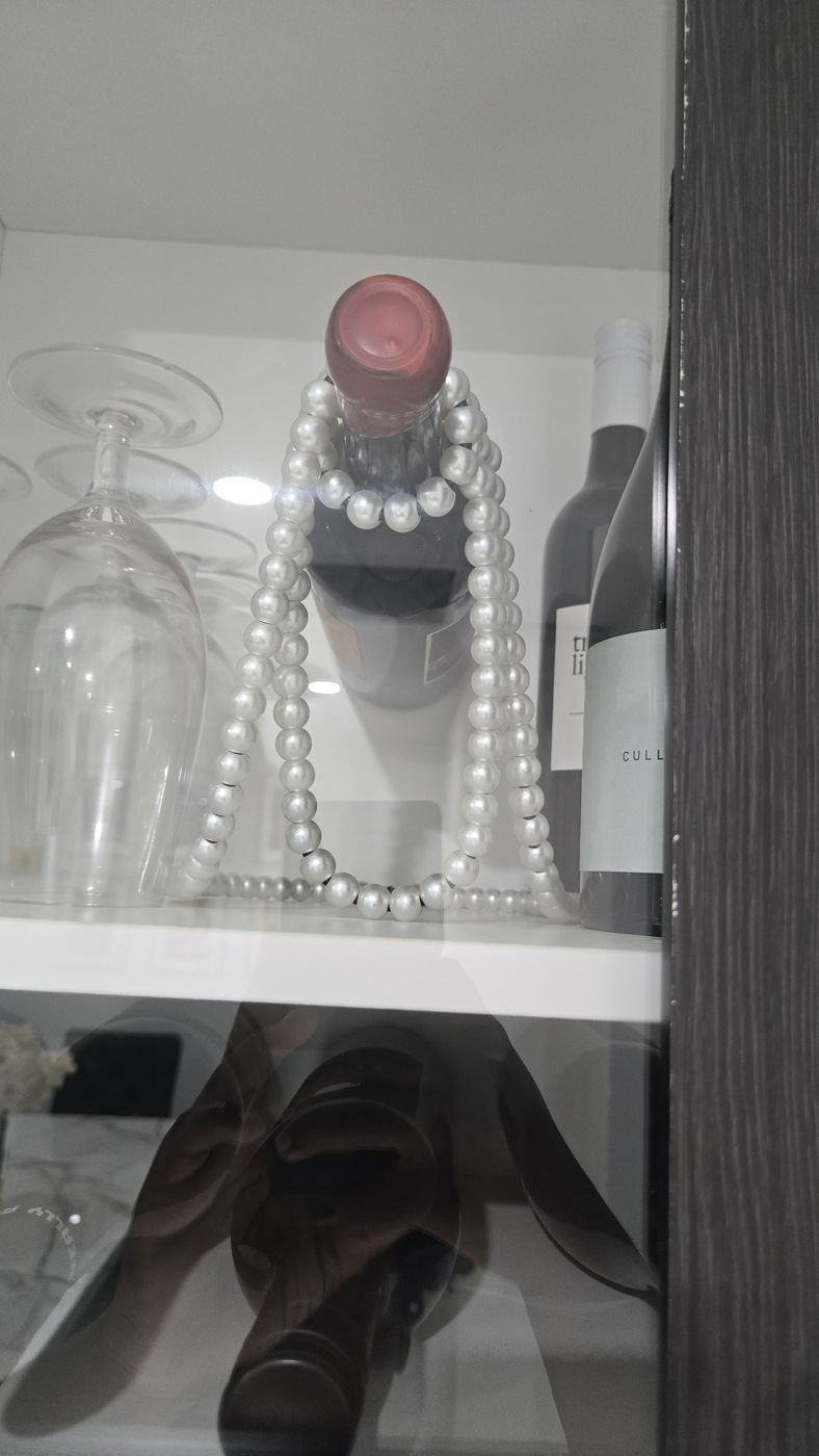 Styled shelf detail with glass and pearls